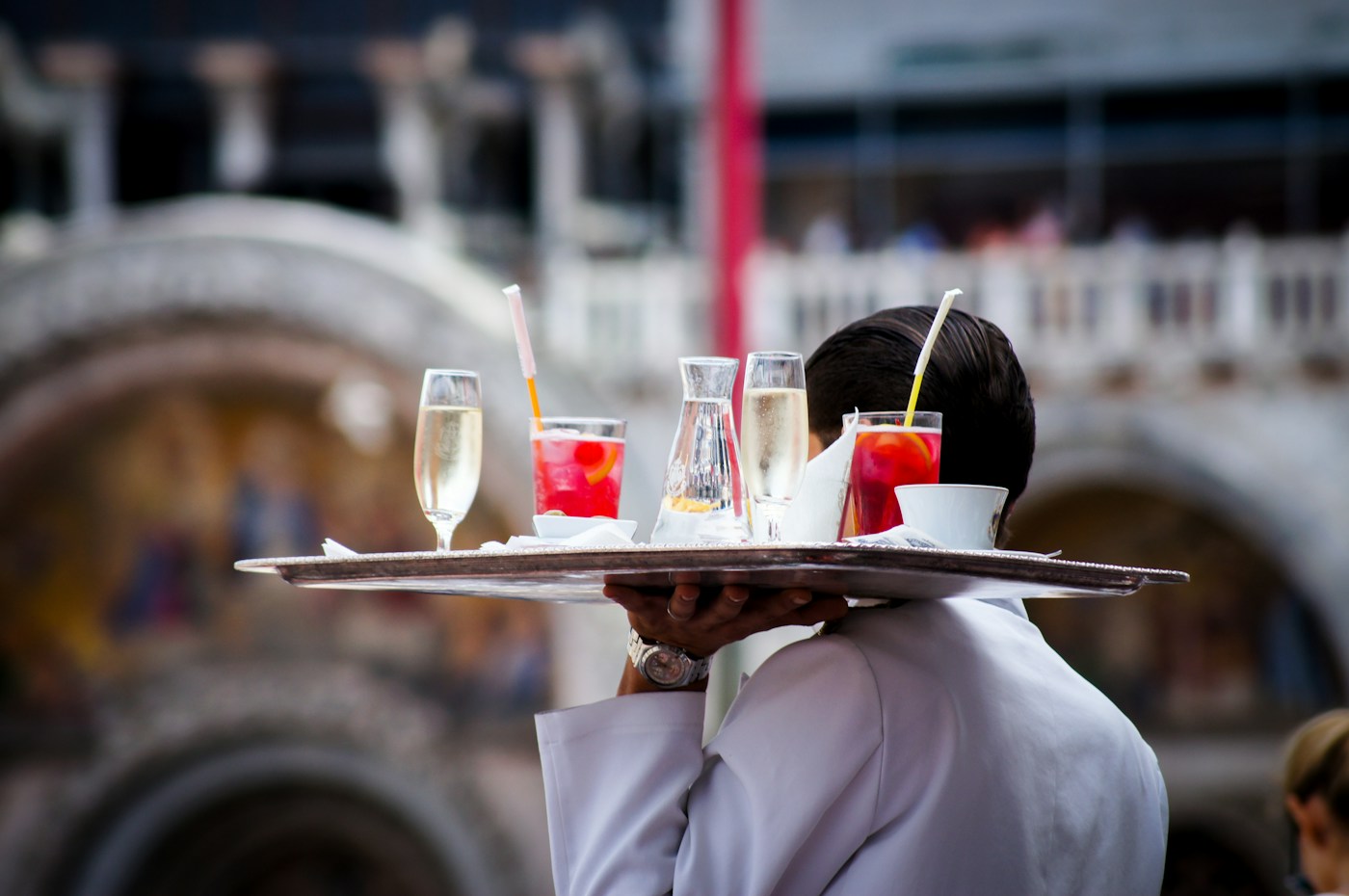 Eine Servicekraft trägt Getränke durch ein Restaurant